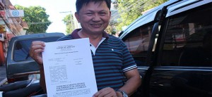 INHIBIT. Mayor Oscar Moreno’s accuser William Guialani shows a copy of his motion against Associate Justice Edgardo Camello.(PHOTO BY NITZ ARANCON)