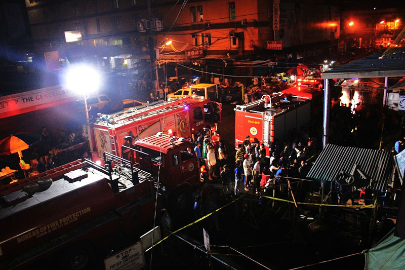 COGON FIRE. Fire fighters and a crowd of onlookers gather outside Cogon market where a fire struck and damaged some stalls on Tuesday night. At left, firemen check a damaged stall. (PHOTOS BY NITZ ARANCON)