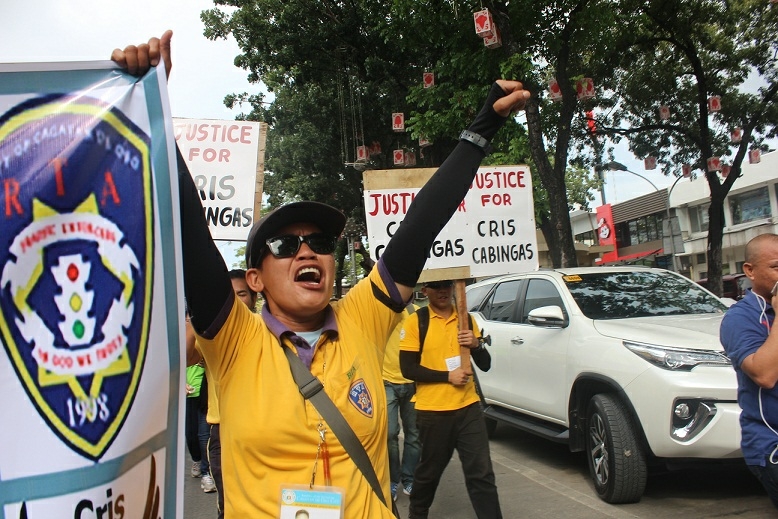 EMOTIONS RUN HIGH. A traffic aide lets out her emotions as she raises her clenched fists and cries for justice for slain Roads and Traffic Administration team leader Cris Cabingas during a street demonstration yesterday. Cabingas was shot dead while managing the vehicular traffic flow near Cogon market  on Friday night. (PHOTO BY NITZ ARANCON)