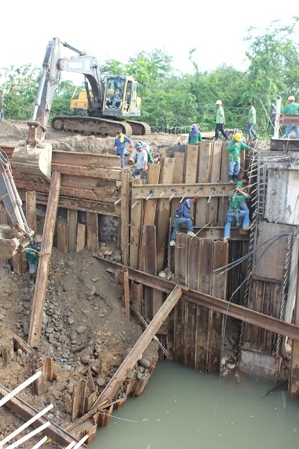 TRAFFIC NIGHTMARE.Construction workers of UKC Builders (left) try to fix a section of an ongoing bridge project in Igpit, Opol, Misamis Oriental, a day after it collapsed. (Photos by Nitz Arancon)