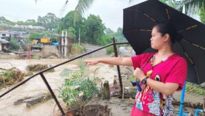 Residents of Barangay Pala-o, Iligan City, wade through knee-deep floodwaters caused by Tropical Typhoon Basyang, forcing families to evacuate overnight. "We just rebuilt our lives after the fire, and niw this happen again," said resident Gee Collantes, as flooding and damaged infrastructure cut off access to essential services. (Photo by Bonita L. Ermac)