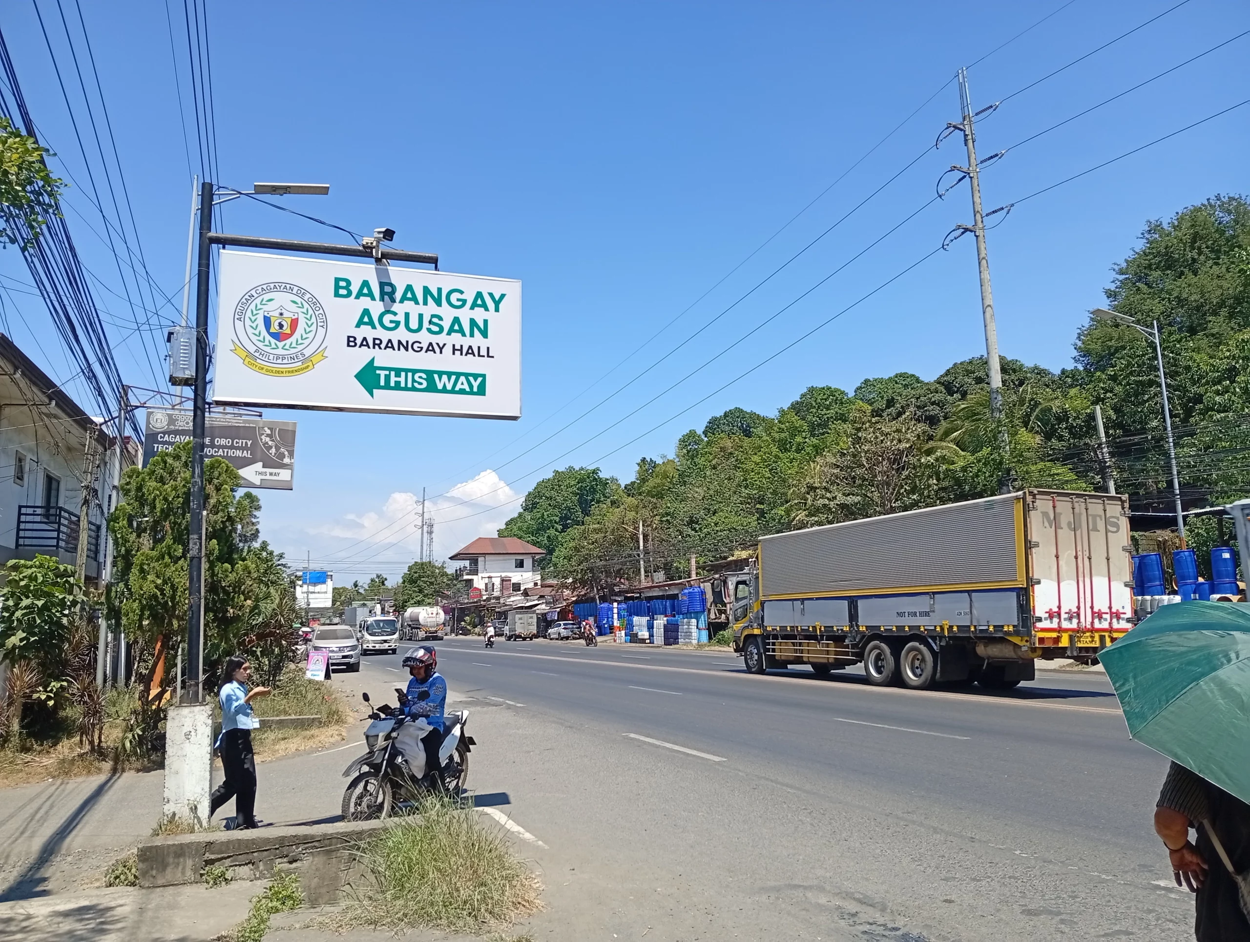 A clear stretch of the national highway in Barangay Agusan, Cagayan de Oro City, showing light traffic conditions at midday.
