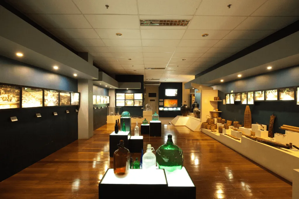 A couple walking through the Museum of Three Cultures at Capitol University in Cagayan de Oro, admiring Mindanaoan artifacts and textiles.
