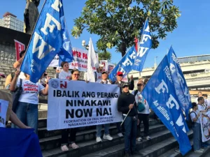 FFW and Nagkaisa Labor Coalition protesters holding banners that read "Ibalik ang perang ninakaw" during a labor rights rally in the Philippines.