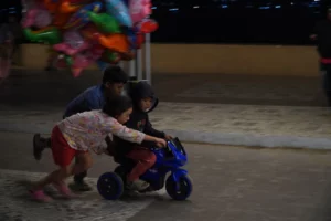 Children playing with push cars on the sidewalk of Lake Lanao in Marawi City during Ramadan.