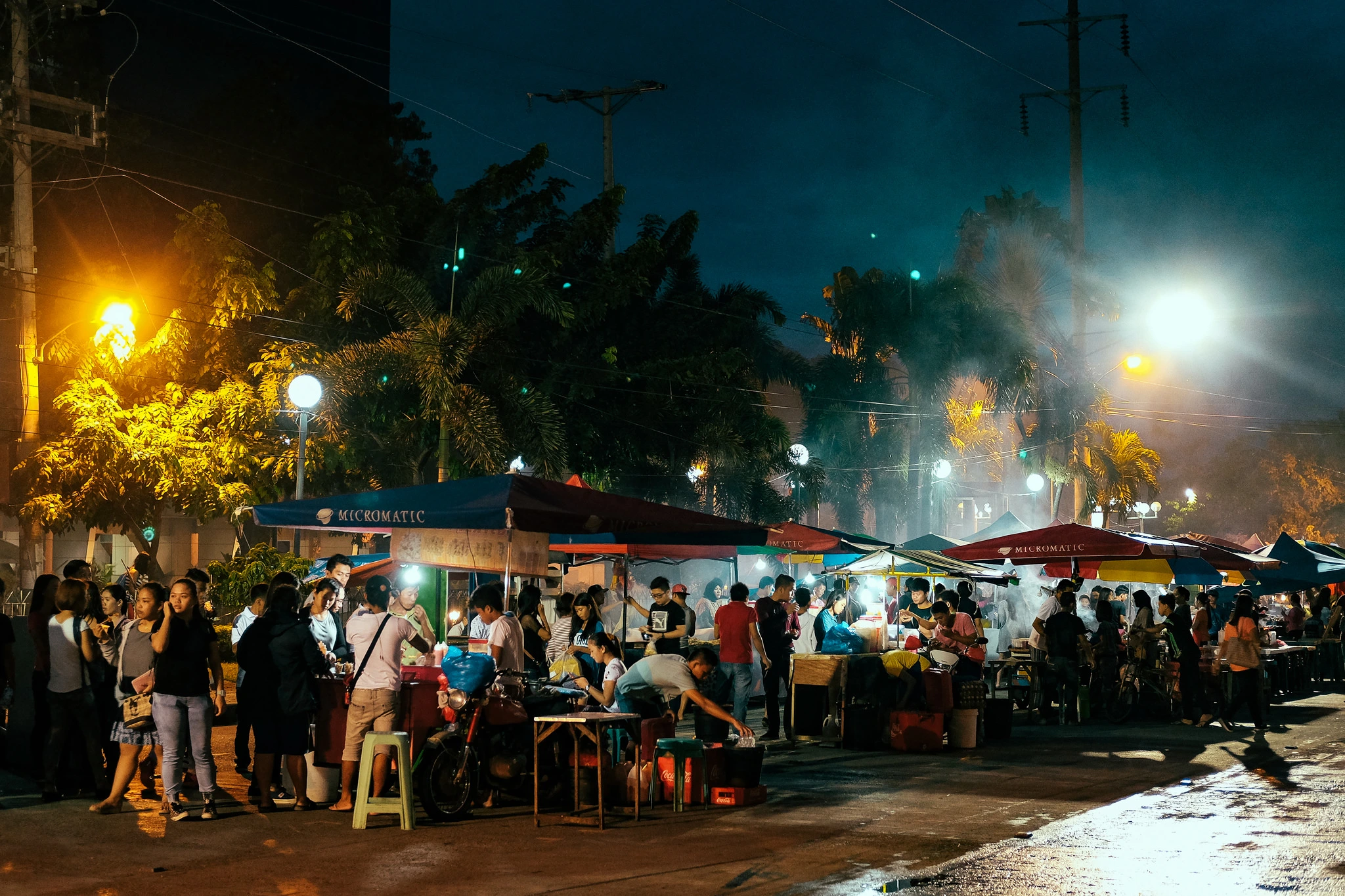 A couple eating street food at a night market in Mindanao, capturing a casual and fun date vibe.