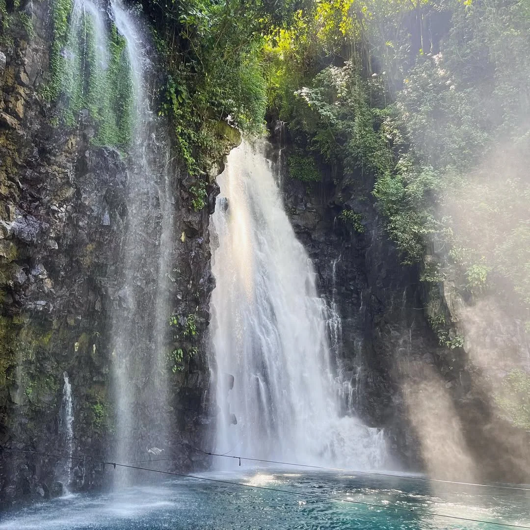 A couple hiking down the scenic steps to Tinago Falls in Iligan City, Mindanao, representing an adventure-themed nature date.