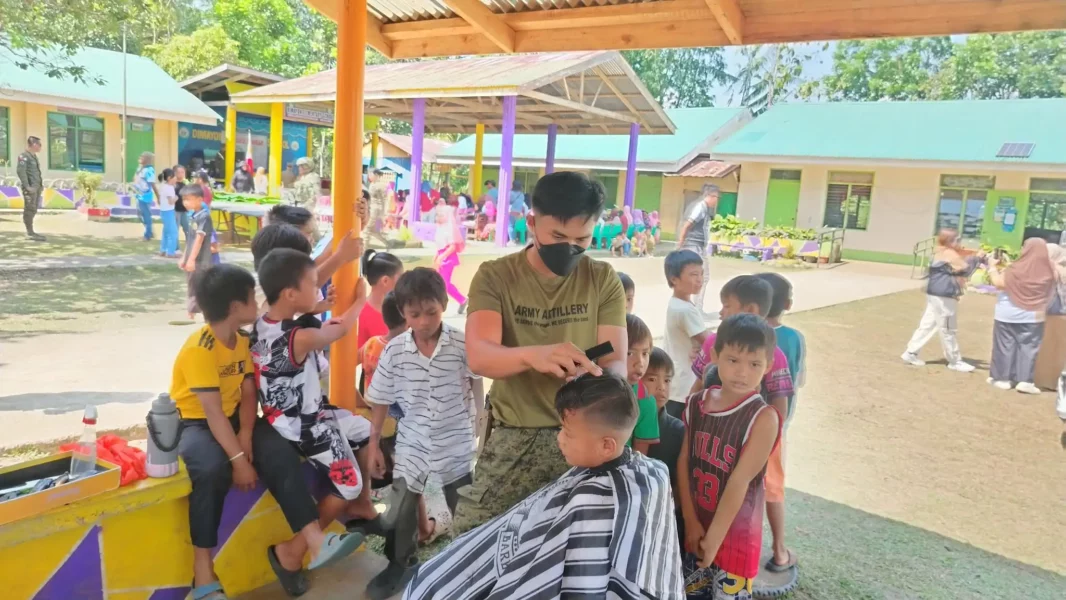 A Philippine Army soldier giving a free haircut to a local resident during a community service outreach in Tagoloan.