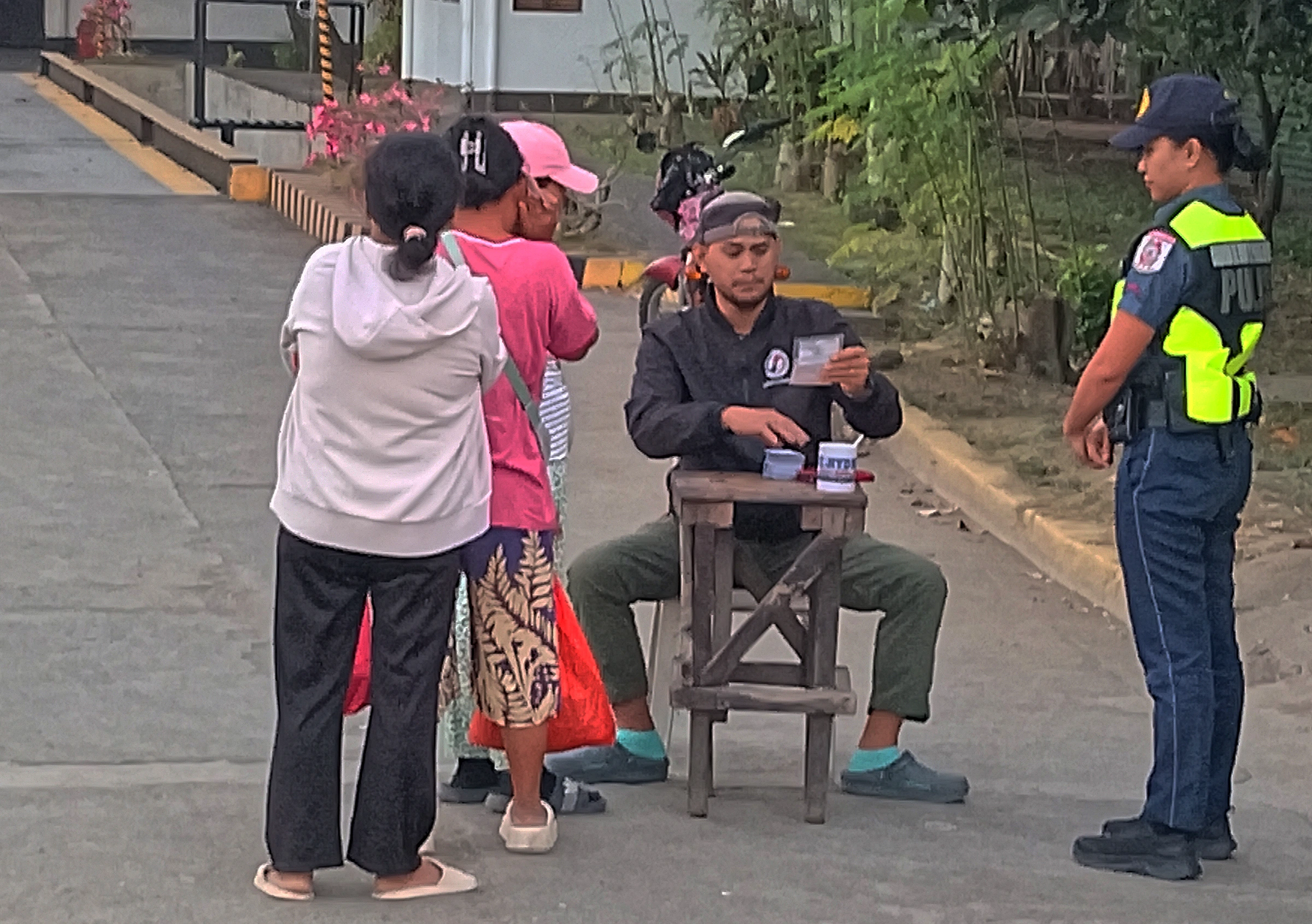 NFA worker verifying identification cards and issuing coupons to rice buyers in Cagayan de Oro.