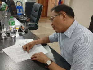 Misamis Oriental Finance Committee Chair Rommel Maslog holding a COA memorandum during a session to explain the ₱1.1 billion reduction in the provincial budget.