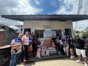 Leaders of the Tagoloan Eagles and Lady Eagles Clubs standing alongside local officials outside the Losina Child Development Center with donated school supplies and cement bags.