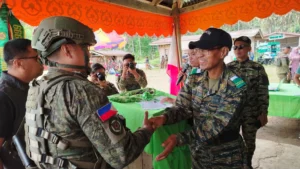 Officials and commanders from the MILF 127th Bilal Base Command, Philippine Army 44th Infantry Battalion, and Munai Municipal Police Station holding signed peace resolutions during a community gathering.