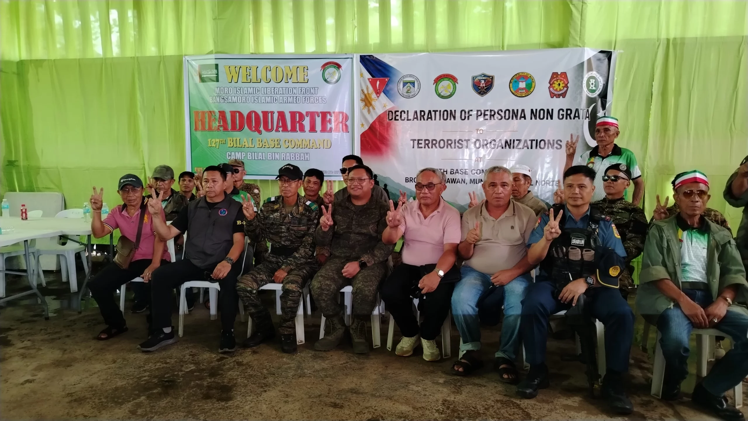 Group photo of MILF commanders, Philippine Army officers, and police standing in front of a banner declaring terrorist groups persona non grata in Munai, Lanao del Norte.