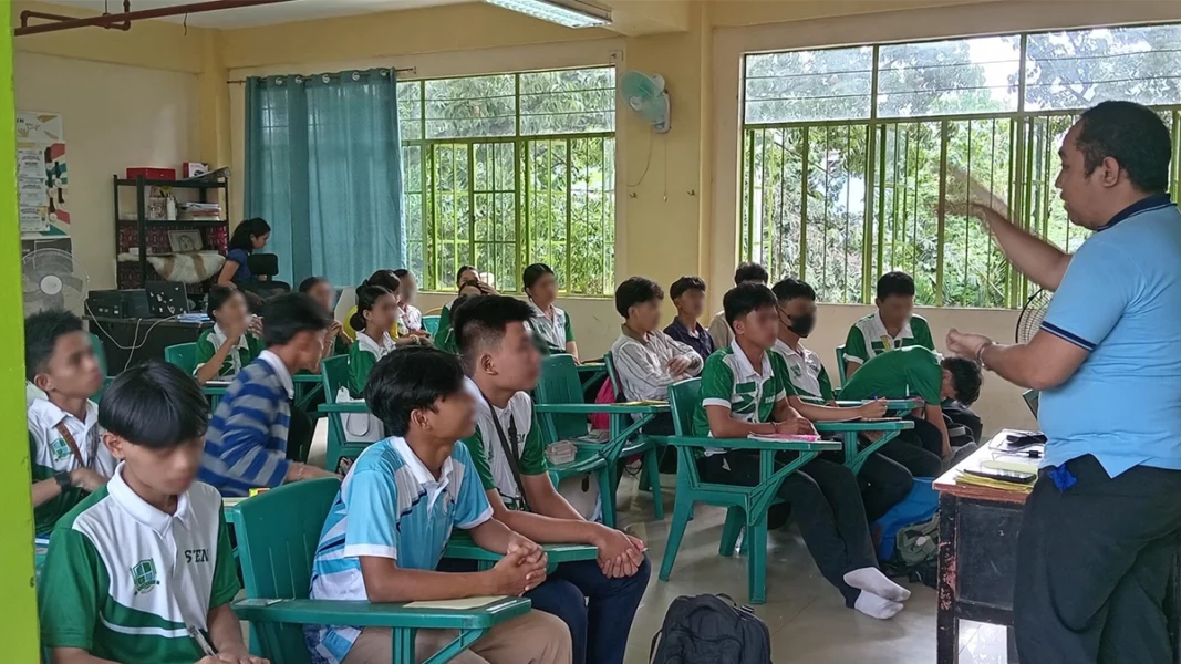 A group of high school students sitting in a circle during an outdoor peer-support discussion on an academic campus in Cagayan de Oro City.
