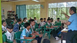 A group of high school students sitting in a circle during an outdoor peer-support discussion on an academic campus in Cagayan de Oro City.