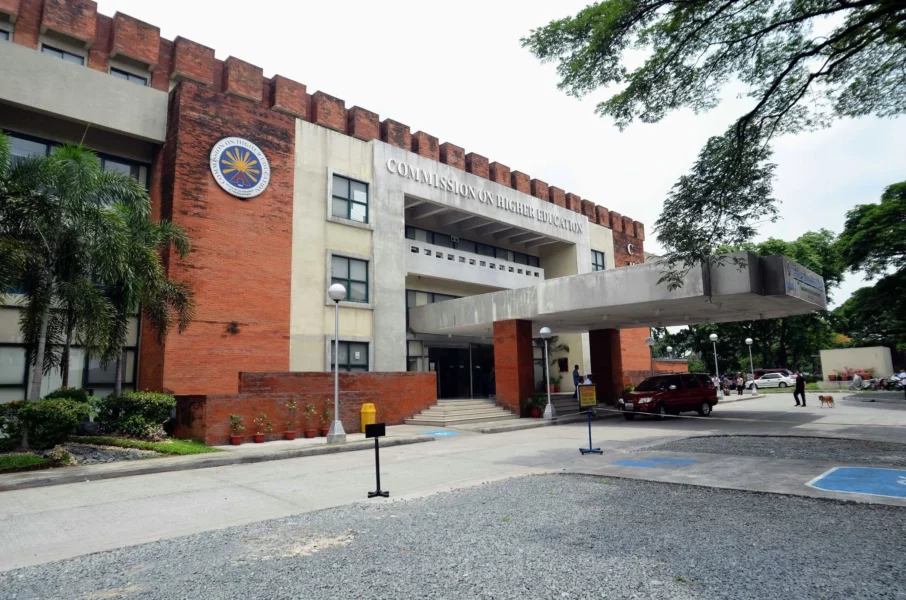 The exterior facade and official signage of the Commission on Higher Education central office building in Quezon City.