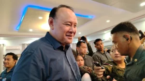 Defense Secretary Gilberto Teodoro Jr. speaking at a podium during a press conference at Camp Evangelista.