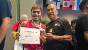 National boxing coach Elmer Pamisa standing proudly alongside boxer Carlo Paalam as they hold the gold medal trophy at the Eindhoven Box Cup in the Netherlands.