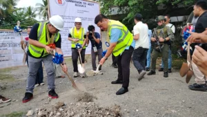 National Bureau of Investigation Director Melvin Matibag, Iligan District Chief Medrobel Ylanan, and Mayor Frederick Siao hold shovels at a construction site dirt mound during a groundbreaking ceremony.