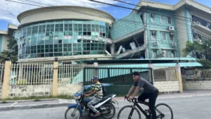 Visible cracks and structural damage on a concrete school building at the Notre Dame of Dadiangas University Integrated Basic Education Department campus in General Santos City following a magnitude 7.8 earthquake.