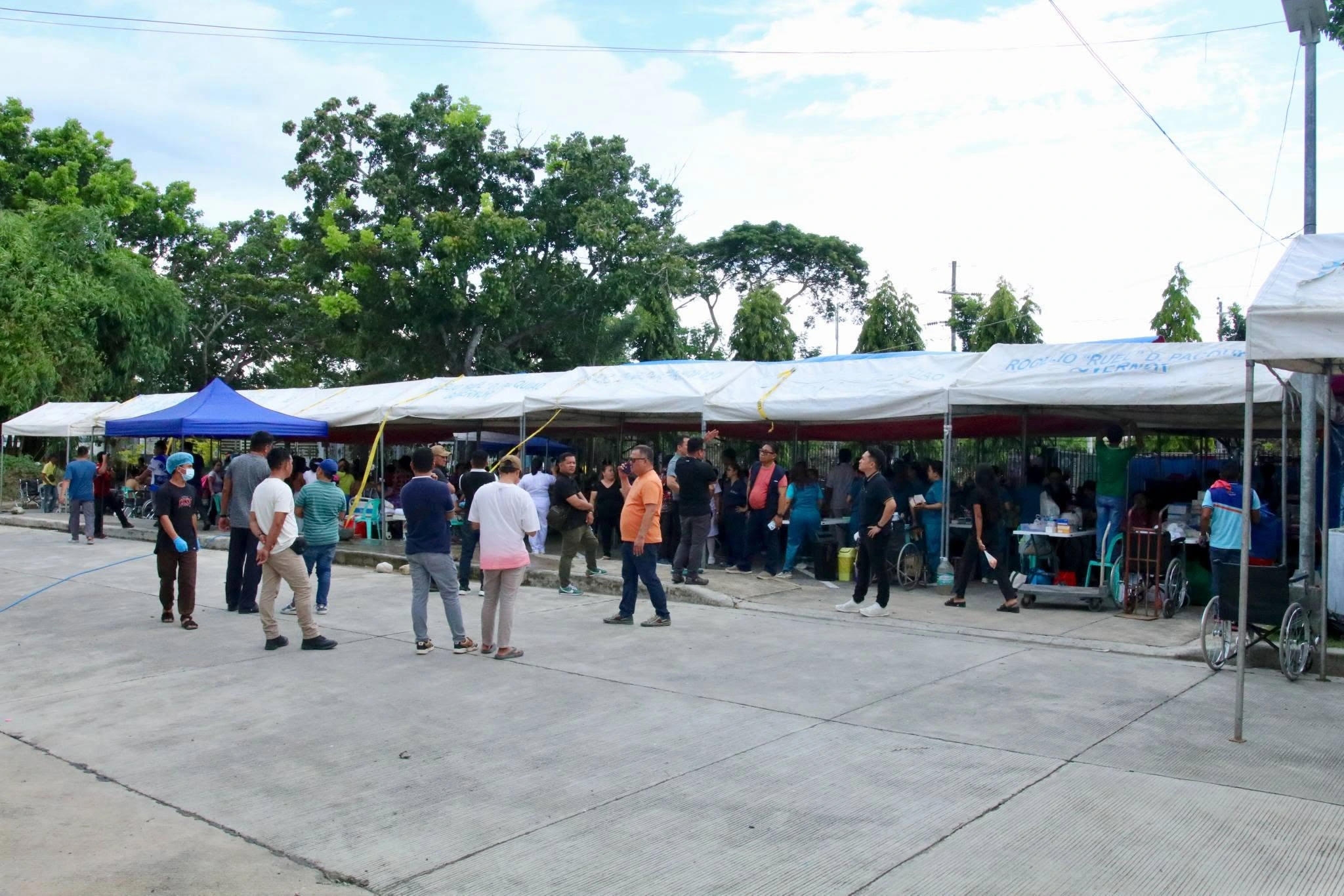 Patients and medical staff gather under temporary outdoor triage tents outside the Sarangani Provincial Hospital compound in Alabel after a magnitude 7.8 earthquake.