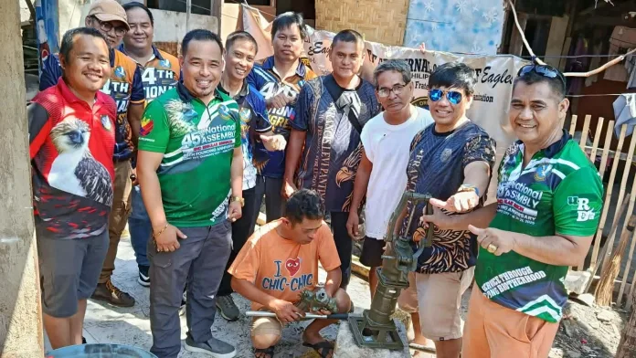 NMR XII Bagwis Dos Governor Archie Cabingas Ello and Tagoloan Eagles Club members pose with local residents next to a newly installed community water pump in Tagoloan, Misamis Oriental.