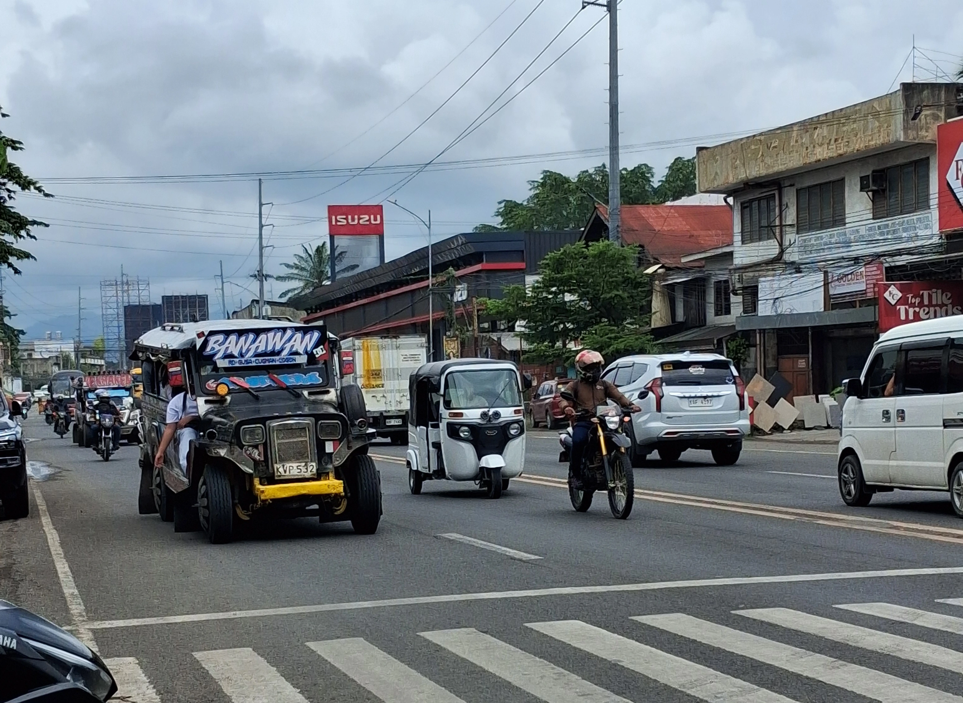 DRIVERS UNDER PRESSURE. Public utility jeepneys, taxis, motorcycles and other vehicles ply a major highway in Cagayan de Oro City on Tuesday as a fresh round of fuel price hikes takes effect, with diesel rising by ₱10.68 per liter, gasoline by ₱3.65, and kerosene by ₱11.77, adding pressure on public transport drivers and motorists already grappling with higher operating costs. (Photo by Ben Balce)