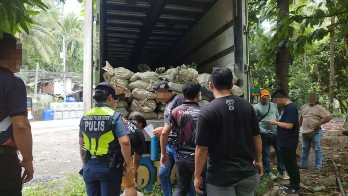 Law enforcement personnel and DENR inspectors document open cargo sacks filled with suspected copper mineral ore inside an abandoned truck in Barangay Buru-un, Iligan City, on Monday, July 27, 2026. Authorities initiated the recovery operation after local residents alerted police that unidentified individuals were attempting to break into the vehicle and steal its unattended freight. (Supplied Photo)