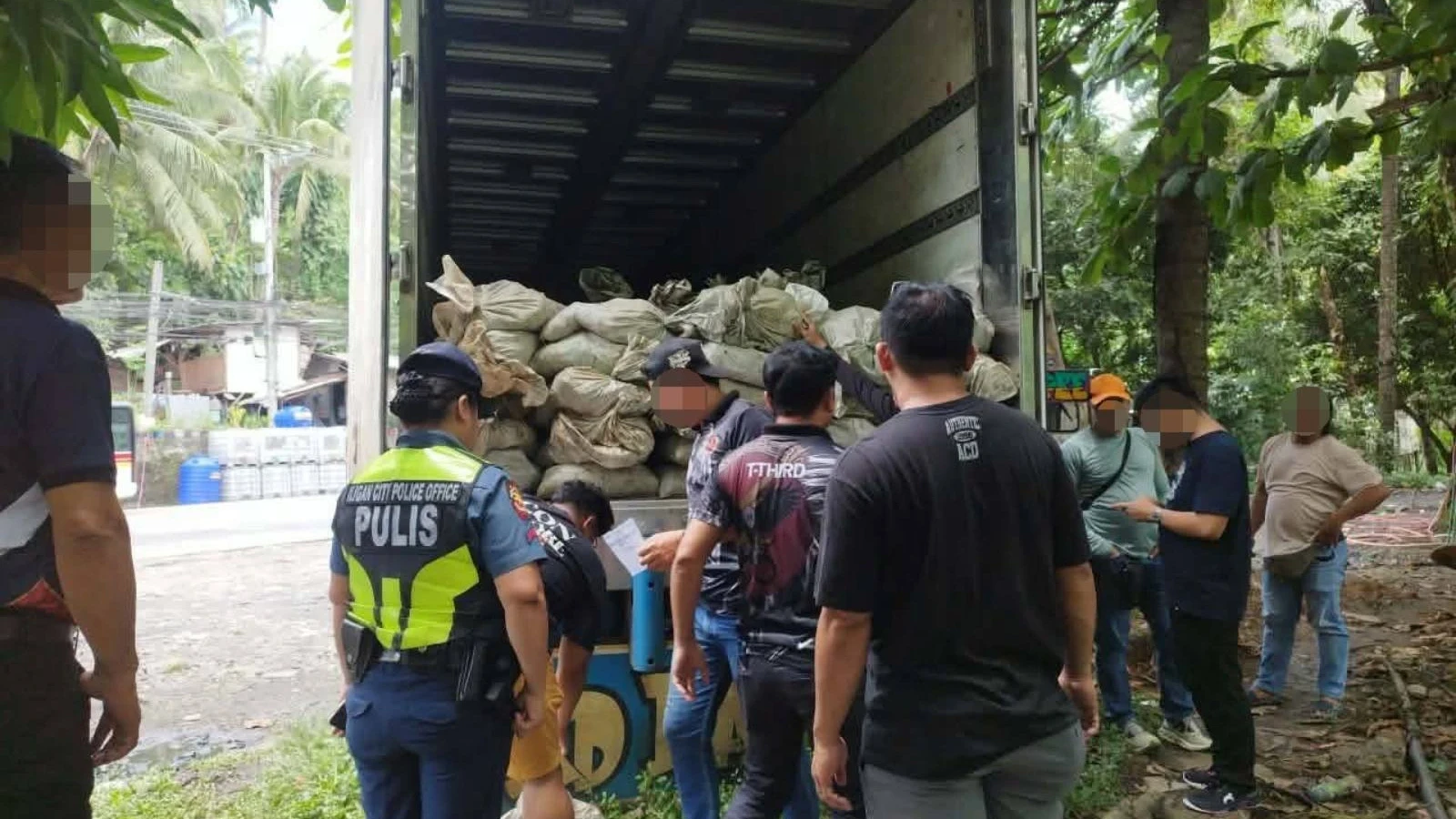 Law enforcement personnel and DENR inspectors document open cargo sacks filled with suspected copper mineral ore inside an abandoned truck in Barangay Buru-un, Iligan City, on Monday, July 27, 2026. Authorities initiated the recovery operation after local residents alerted police that unidentified individuals were attempting to break into the vehicle and steal its unattended freight. (Supplied Photo)