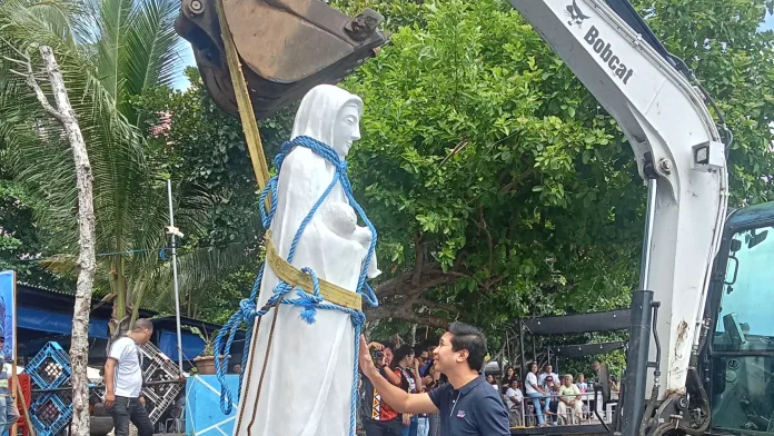 Gingoog City Mayor Erick G. Cañosa offers a prayer before the seven-foot-tall, 1,500-kilogram Our Lady Stella Maris (Star of the Sea) statue is transported about 1.5 kilometers offshore for installation at the underwater Marian sanctuary in Puntod Shoal, a Marine Protected Area in Gingoog City, on July 30. (Photo by Edwin Iyo)