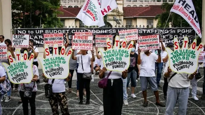 Demonstrators representing labor unions and healthcare advocacy groups, including the Federation of Free Workers, raise placards during a rally to protest the transfer of ₱89.9 billion in PhilHealth funds, Monday, July 13, 2026. The coalition called on the administration to reverse the fiscal directive and protect state-managed insurance assets earmarked for universal healthcare services. Supplied Photo