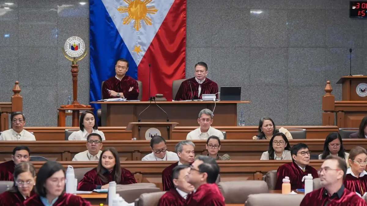 Senator-judges wearing Oxford crimson robes sit at their desks in the plenary hall as Senate President Win Gatchalian opens the impeachment trial of Vice President Sara Duterte.