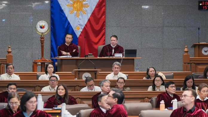 Senator-judges wearing Oxford crimson robes sit at their desks in the plenary hall as Senate President Win Gatchalian opens the impeachment trial of Vice President Sara Duterte.