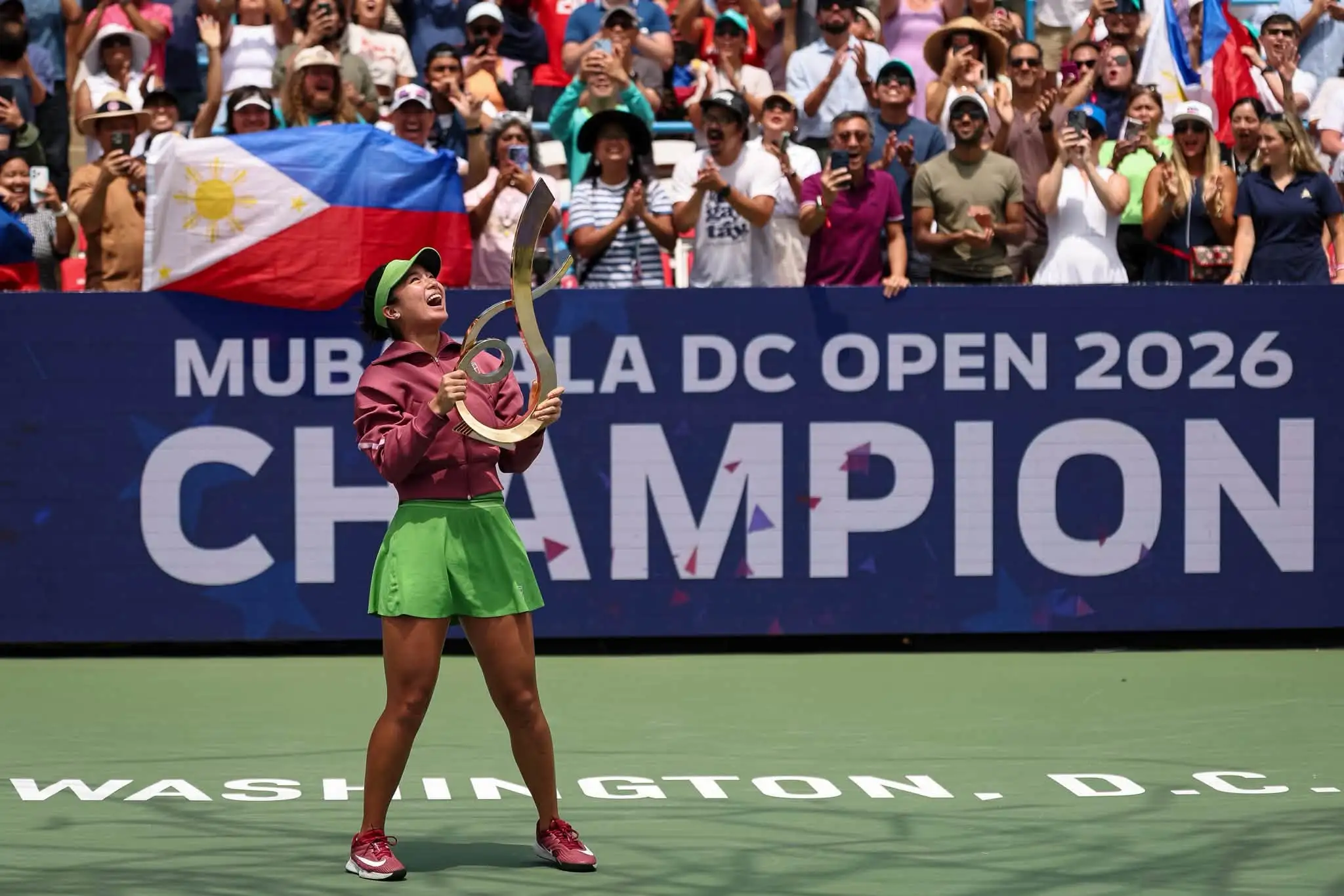 Alex Eala cheers exuberantly while holding her trophy high in front of supportive fans and a Philippine flag following her final victory on Tuesday, Aug. 4, 2026 (PH TIME. The 21-year-old dedicated her inaugural WTA Tour singles title to her family, training team, and the Filipino community worldwide. (Photo courtesy of WTA Facebook page)