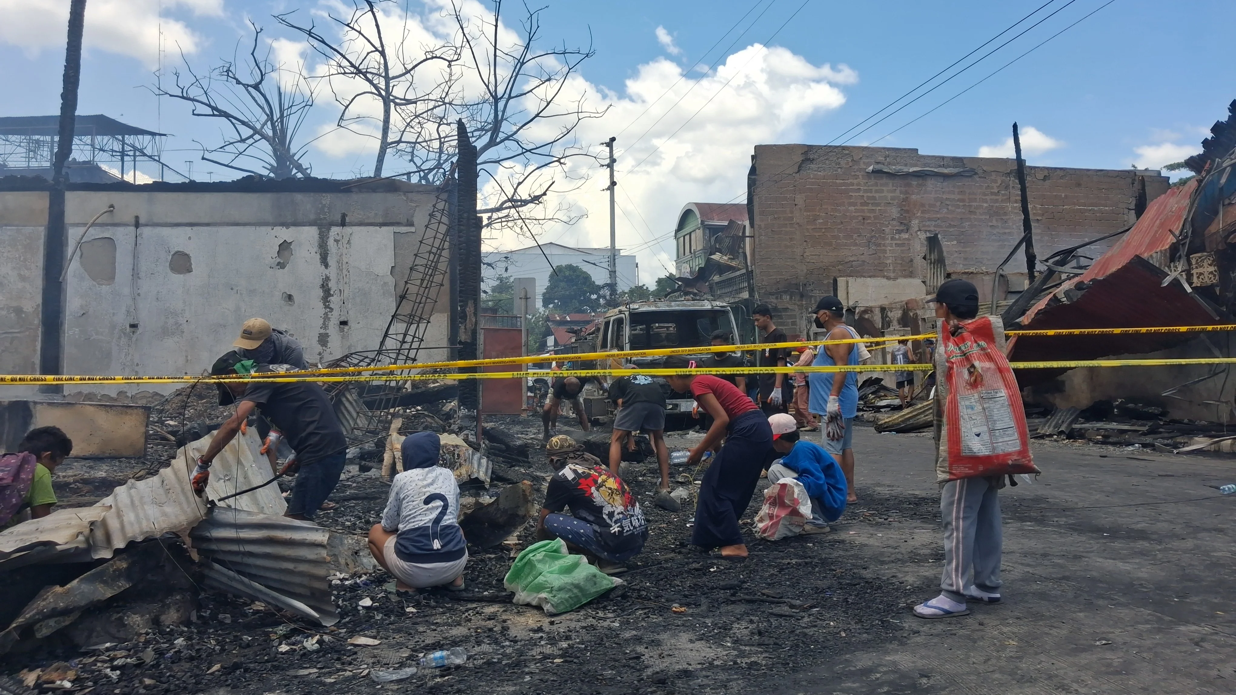 FIRE AFTERMATH. Residents sift through the charred remains of their homes on Burgos Street in Barangay 7, Cagayan de Oro City, a day after a fire destroyed seven houses and damaged three others. The blaze, which burned for nearly three hours, left an estimated ₱8 million in property damage as authorities continued investigating its cause. Photo by Ben Balce