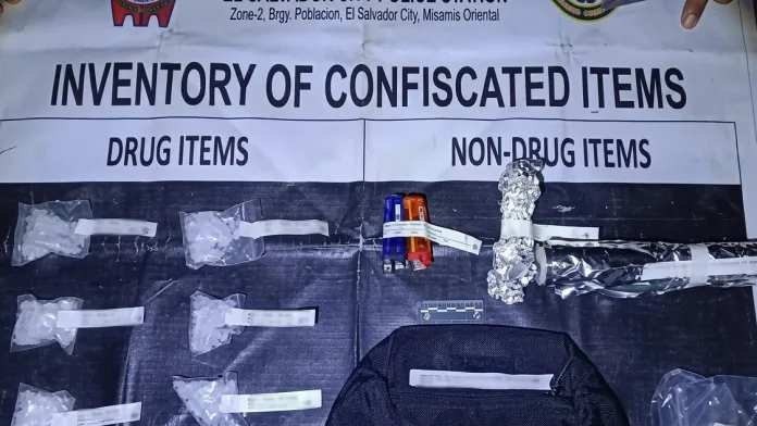 DRUG BUST EVIDENTIARY EXHIBIT: Six heat-sealed plastic sachets containing approximately 155 grams of suspected shabu, valued at ₱1.054 million, sit alongside seized drug paraphernalia on an official inventory mat at the El Salvador City Police Station in Misamis Oriental. (Photo courtesy of PNP-Misamis Oriental)