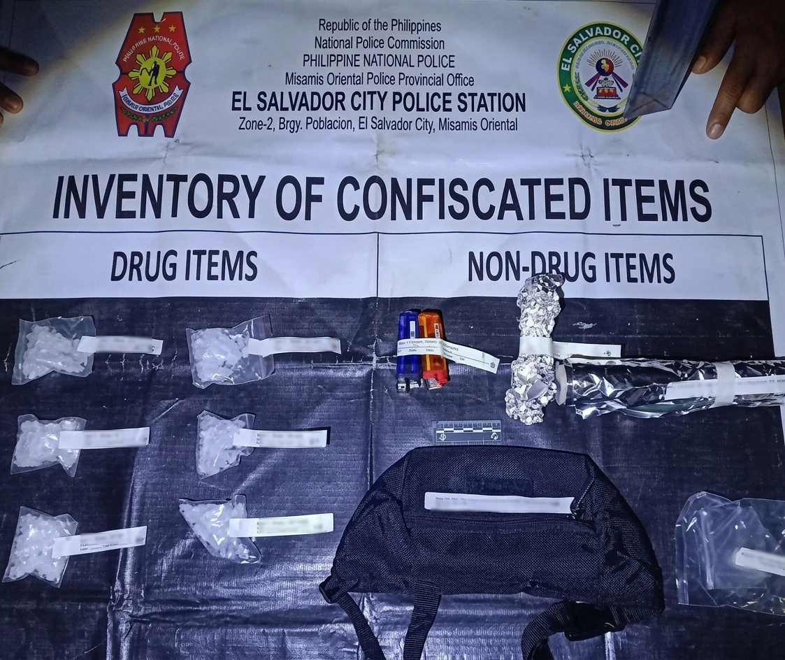 DRUG BUST EVIDENTIARY EXHIBIT: Six heat-sealed plastic sachets containing approximately 155 grams of suspected shabu, valued at ₱1.054 million, sit alongside seized drug paraphernalia on an official inventory mat at the El Salvador City Police Station in Misamis Oriental. (Photo courtesy of PNP-Misamis Oriental)