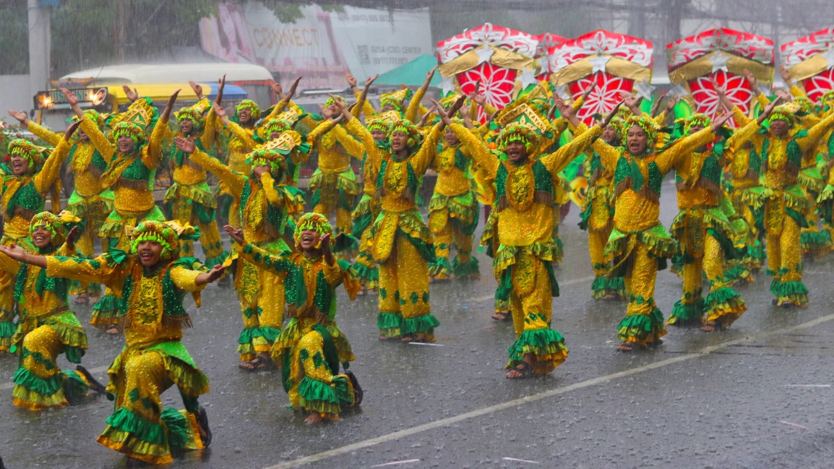 DANCING THROUGH THE RAIN. Dancers from barangay Agusan clad in vibrant yellow and green costumes brave a heavy downpour during the Higalaay Festival 2026 Street Dancing Competition along the streets of Cagayan de Oro City. Agusan claimed the championship title among seven participating contingents, followed by Barangay Carmen in second place and Barangay 17 in third. (Photo by Mikhail Christian B. Gallana)