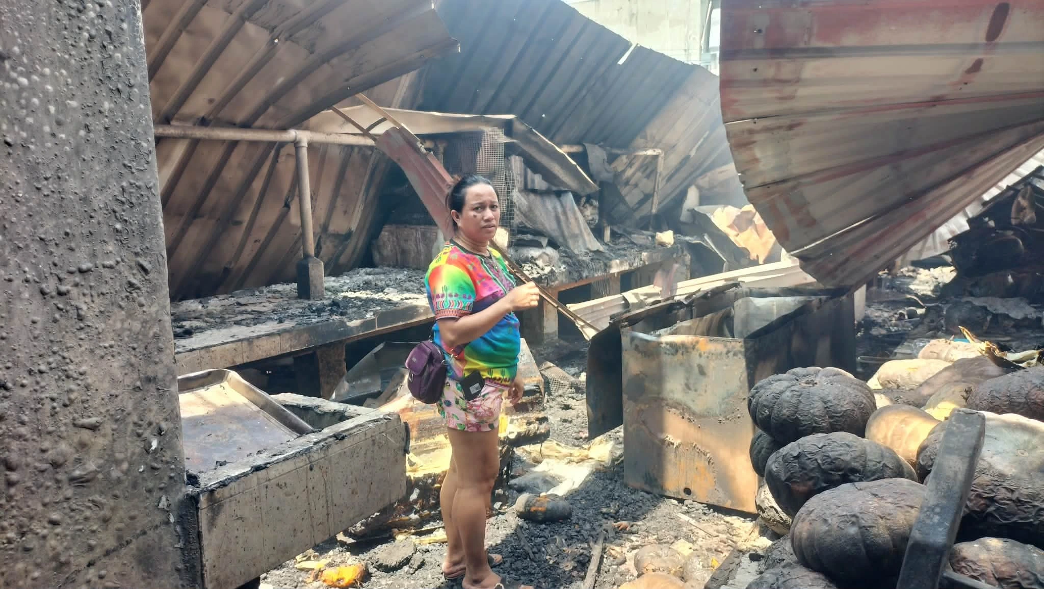 WHAT REMAINS. Stall owner Alnie Bismion surveys what remains of her store after the fire destroyed stocks and damaged vehicles used for the family business. (Photo by Bonita L. Ermac)