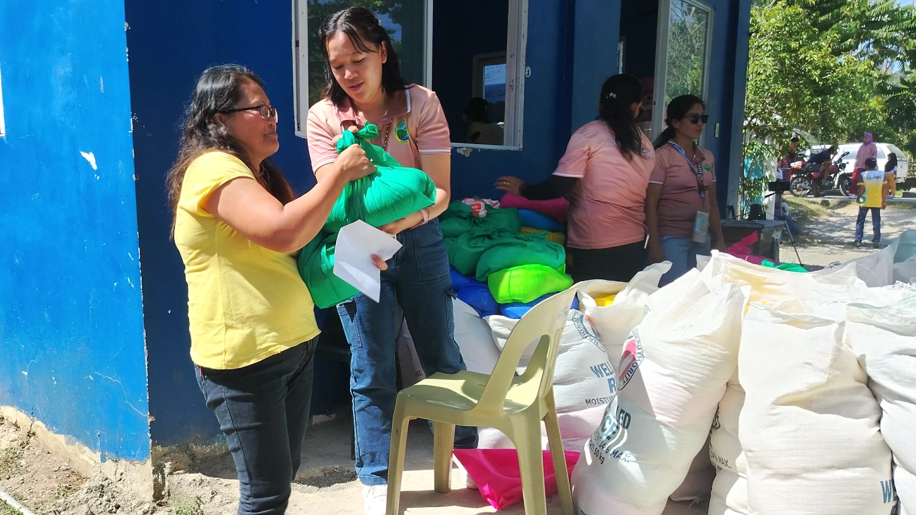 AFFORDABLE GRAIN: A resident in a yellow shirt receives a bag of subsidized rice from a distribution worker during the rollout of Iligan City's "Benteng Bigas Meron Na" program at Barangay Mandulog in Iligan City on Friday, Aug. 14, 2026. (Photo by Bonita L. Ermac)