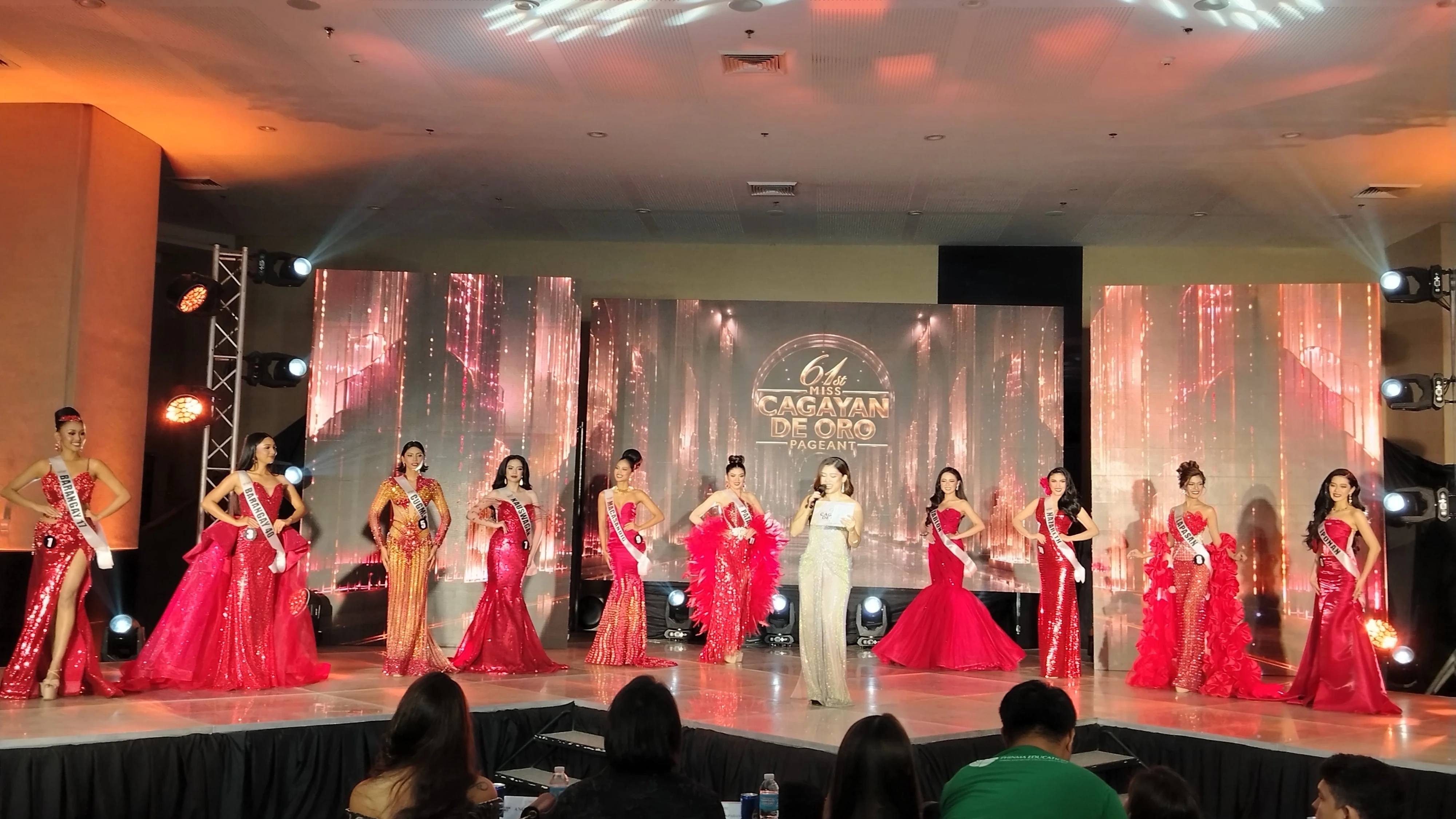 READY FOR THE CROWN. Candidates for Miss Cagayan de Oro 2026 line up in elaborate red and formal gowns on stage while an host speaks during the preliminary competition on Saturday, Aug. 1, 2026. The event marks a key milestone for the contestants as they compete for the city crown in what organizers describe as a "new era" for the annual pageant. (Photo by Shiela Mae Butlig)