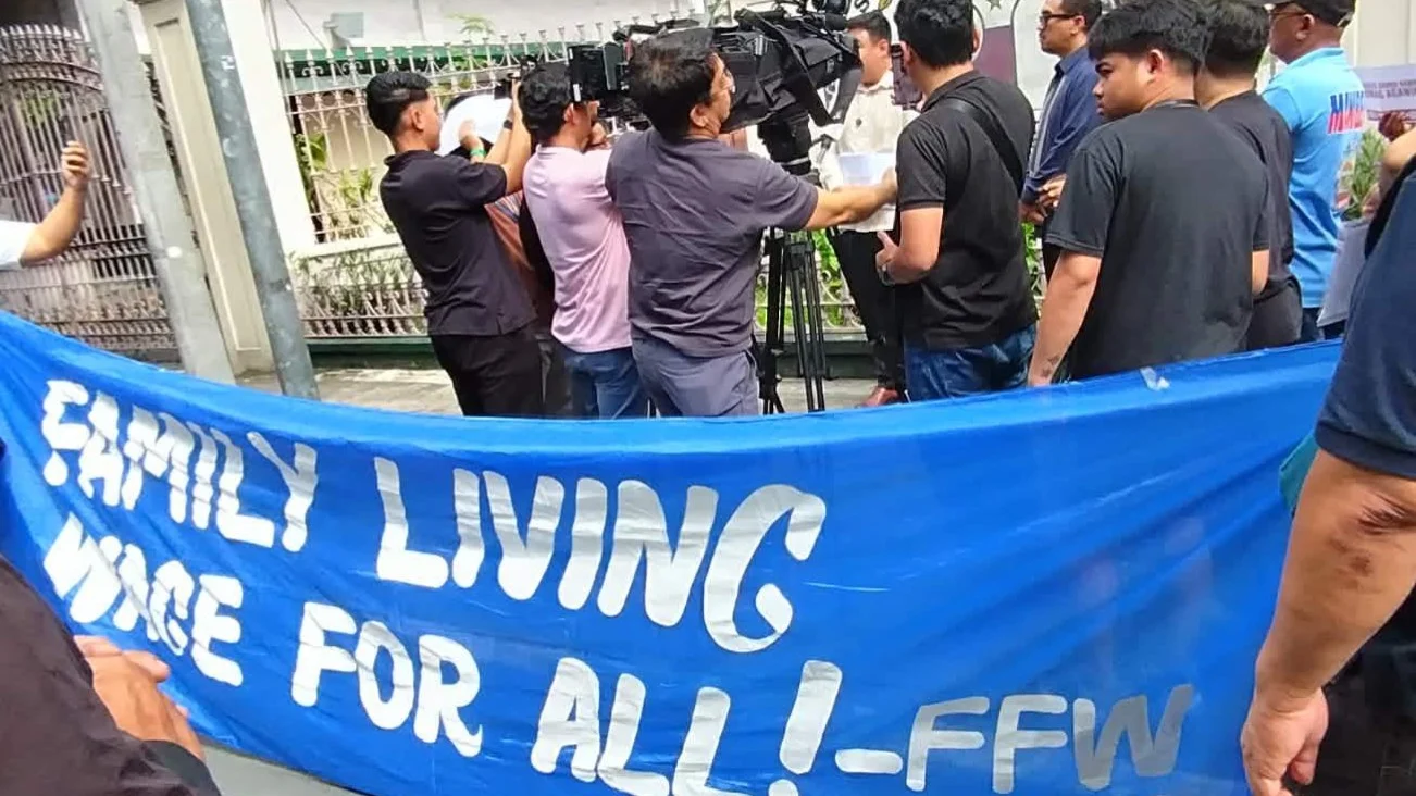 STANDING FOR FAIR WAGES. Labor advocates hold a banner outside the Supreme Court as media cover the protest. While legal battles delay Metro Manila's ₱85 wage hike under Wage Order No. NCR-27, Northern Mindanao workers remain under Wage Order No. RX-24, which raises daily minimum wages by ₱39 (to ₱485–₱500) effective May 1, 2026. However, the Metro Manila court dispute could set a precedent for how future regional wage orders are challenged and implemented nationwide. (Supplied photo)