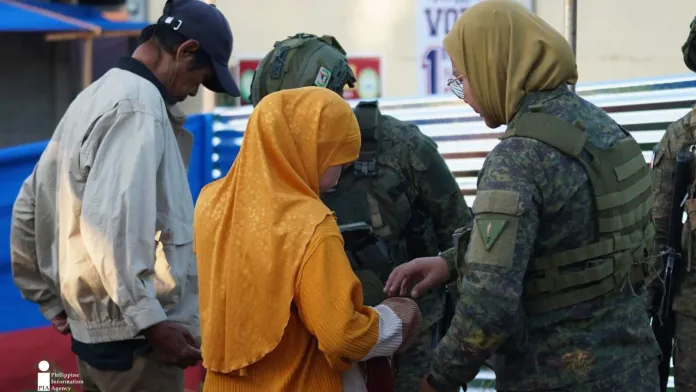 SECURITY CHECK. Security personnel check a voter before allowing entry to a polling center during the Bangsamoro parliamentary elections on Sept. 14 in Lanao del Sur. The inspection was part of security measures to keep voters and election workers safe. (Photo courtesy of JAKA/PIA-10/Lanao del Sur)