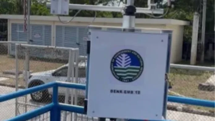 A DENR-EMB Region 10 Continuous Ambient Air Quality Monitoring Station equipment setup featuring meteorological sensors and a branded control box on an outdoor platform.