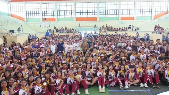 Maragusan Maroon Knights athletes, coaches, and local government leaders hold their championship trophy and medals at the 2026 Davao de Oro Provincial Athletic Association (DDOPAA) Meet. Maragusan finished ahead of the Nabunturan Black Mamba, Compostela Level-Up Warriors, Pantukan Blue Phoenix, and Monkayo Orange Spiders to win the provincial sports meet. (Photo courtesy of Municipality of Maragusan)