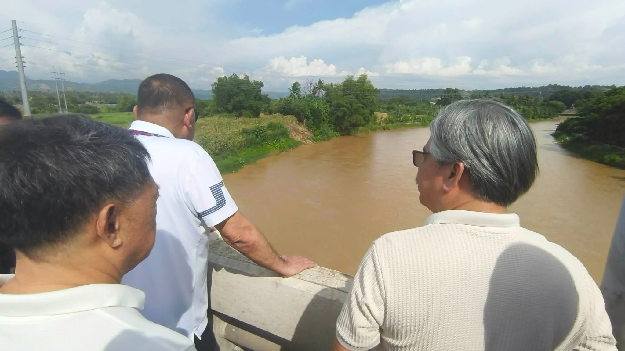 DREDGING PLAN. DPWH Undersecretary Charles Calima (center) inspects the Tagoloan River in Misamis Oriental as the agency explores possible assistance from private quarry companies for dredging works to address its shallow and silted portions. With him are local officials and stakeholders working to fast-track the completion of the Tagoloan Bridge. Photo by Shiela Mae Butlig