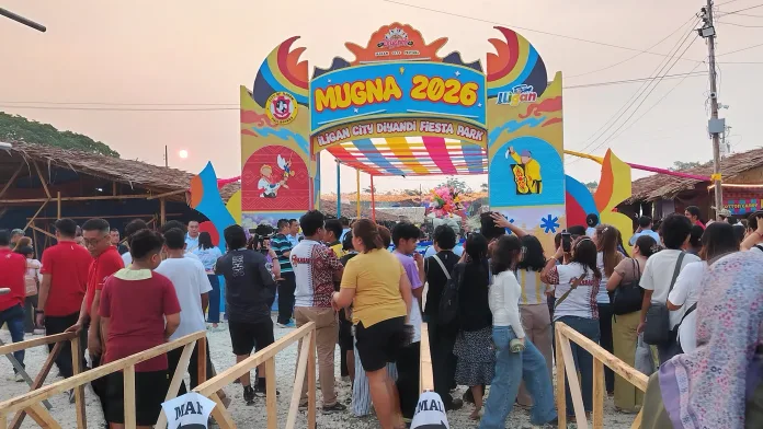 FESTIVAL PARK OPENS: Visitors gather near the decorative entrance archway of Mugna 2026 at its new venue at Ludo Ground in Bayug, Hinaplabon, Iligan City. The fiesta park officially opened on Sept. 2, 2026, as part of Iligan’s month-long Diyandi Festival celebration, bringing together food stall owners, local artisans, and performers to generate economic opportunities for micro and small enterprises across the city. (Photo by Bonita Ermac)