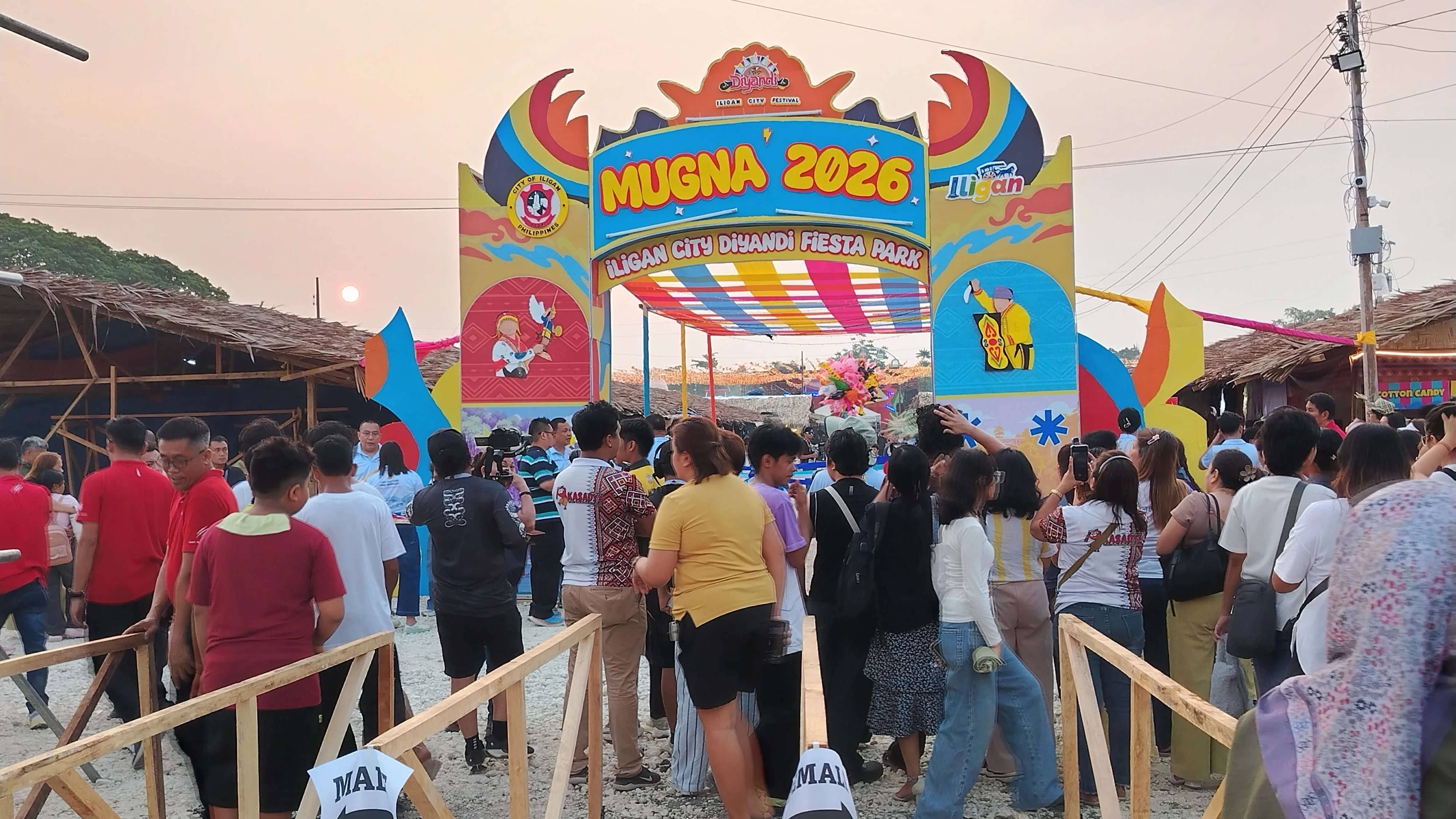 FESTIVAL PARK OPENS: Visitors gather near the decorative entrance archway of Mugna 2026 at its new venue at Ludo Ground in Bayug, Hinaplabon, Iligan City. The fiesta park officially opened on Sept. 2, 2026, as part of Iligan’s month-long Diyandi Festival celebration, bringing together food stall owners, local artisans, and performers to generate economic opportunities for micro and small enterprises across the city. (Photo by Bonita Ermac)
