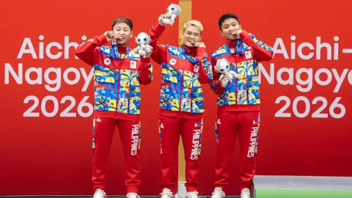 Philippine Women’s Sepak Takraw team members Abegail Sinogbuhan, Jean Marie Sucalit, and Nelly Jay Salon standing proudly on the Asian Games podium while holding their silver medals.