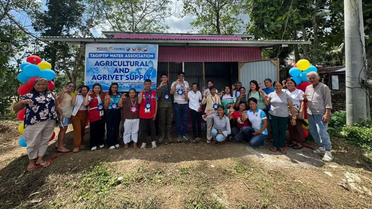 Cabanglasan Mayor Bernie Castillanes, military officials, DSWD representatives, and members of the Tagiptip Water Association pose in front of their newly turned-over agricultural and agrivet supply facility.